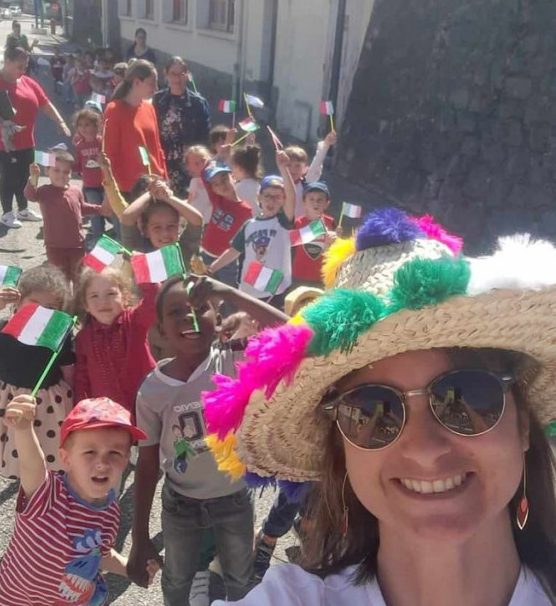 Monitrice qui fait un selfie avec tout le groupe d'enfant et ses collègues derrière